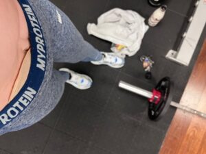 Amy wearing blue gym leggings, with her stoma bag being subtly visible through them.